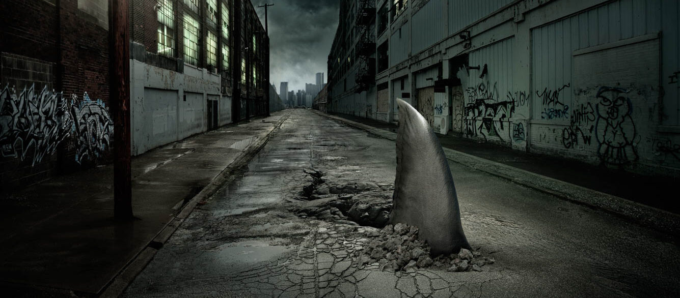 Shark fin swimming in dilapidated city street Shark fin swimming in dilapidated city street