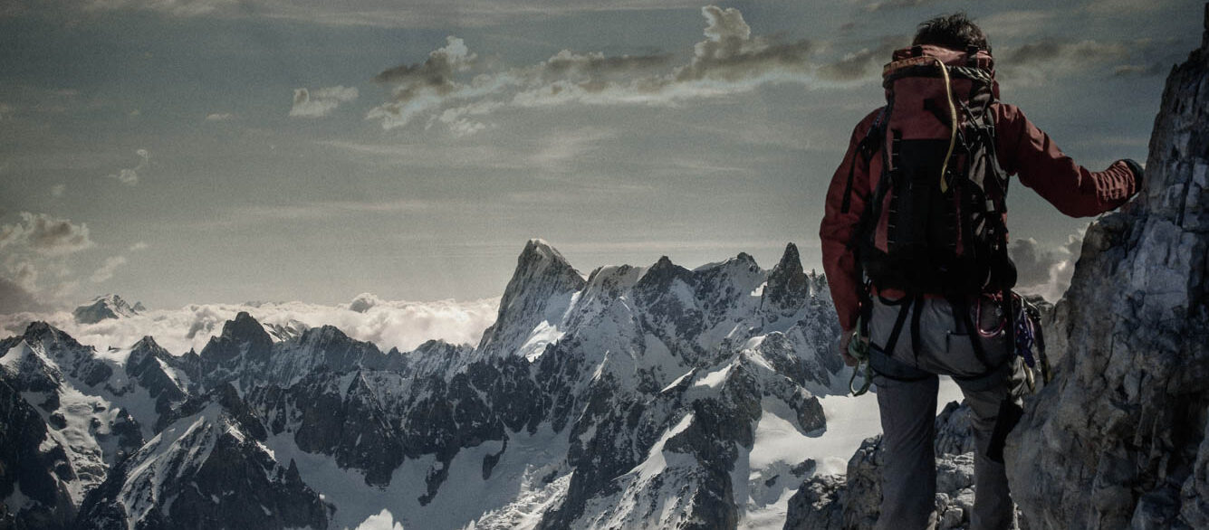 Climber watching a mountain range Climber watching a mountain range