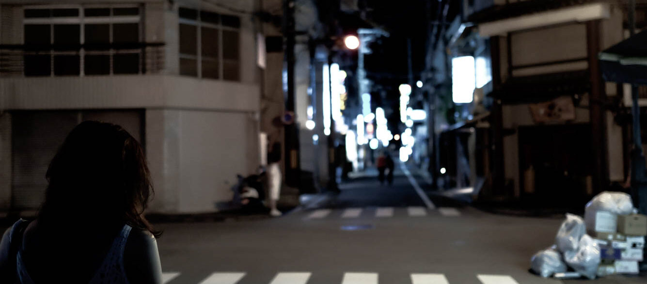 Rear View Of Woman Walking On Street At Night Rear View Of Woman Walking On Street At Night