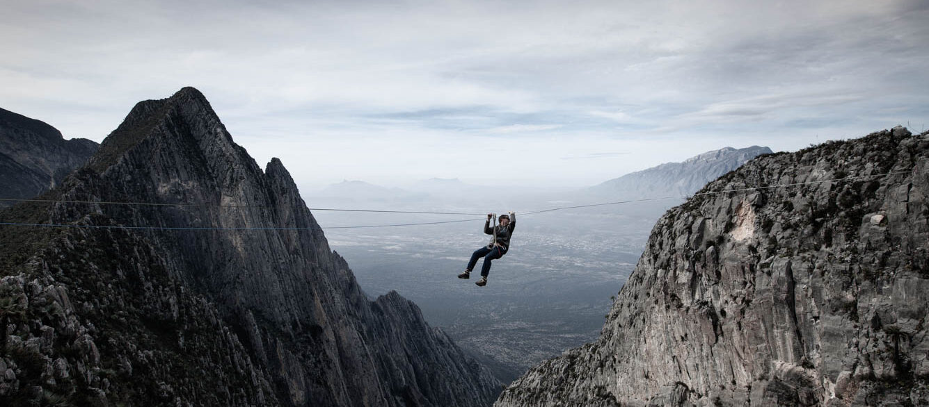 Man Zip Lines Across Canyon Man Zip Lines Across Canyon