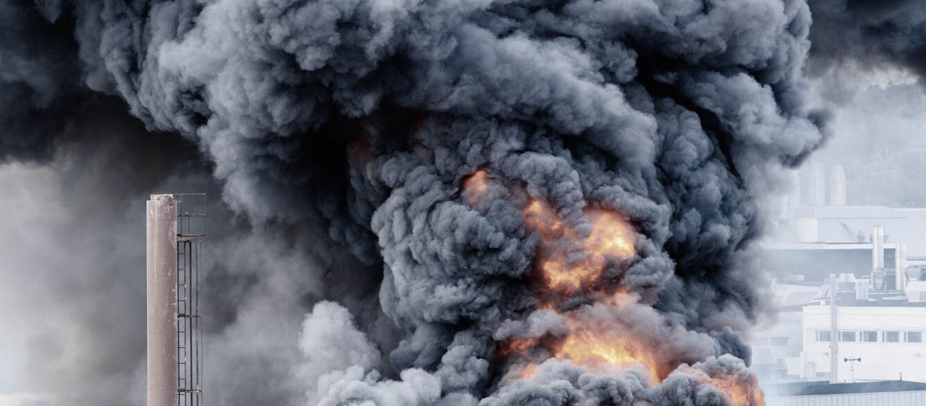 Building in fire Large smoke plume and fire rising from building