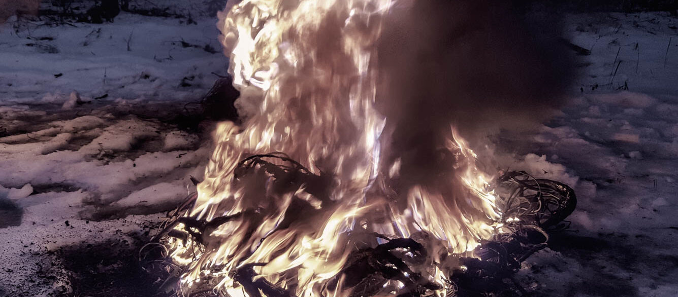 a fire is burning from a pile of wires in the winter forest. Environmental pollution a fire is burning from a pile of wires in the winter forest. Environmental pollution