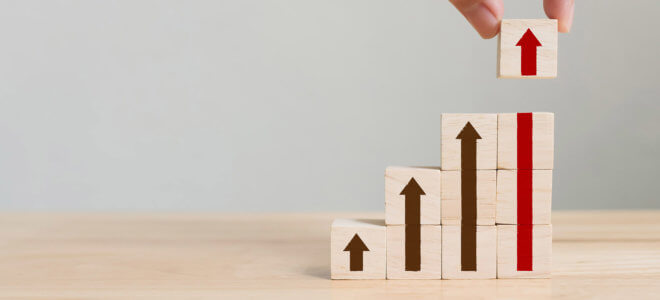 Hand arranging wood block stacking as step stair with arrow up. Ladder career path concept for business growth success process