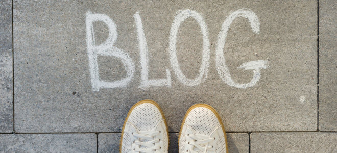 View from above, female feet with text blog written on grey sidewalk