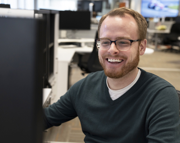 Greg Johnson working on his next viral blog post Bearded man smiling at computer