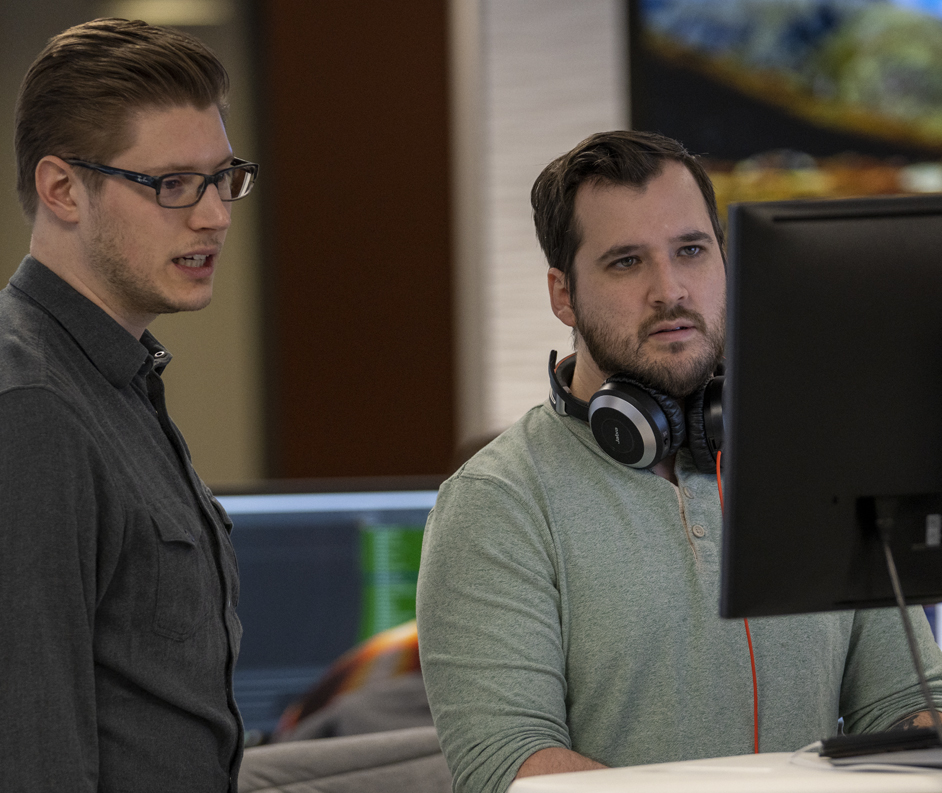 What We Do - Compliance 2 male website developers looking at computer screen