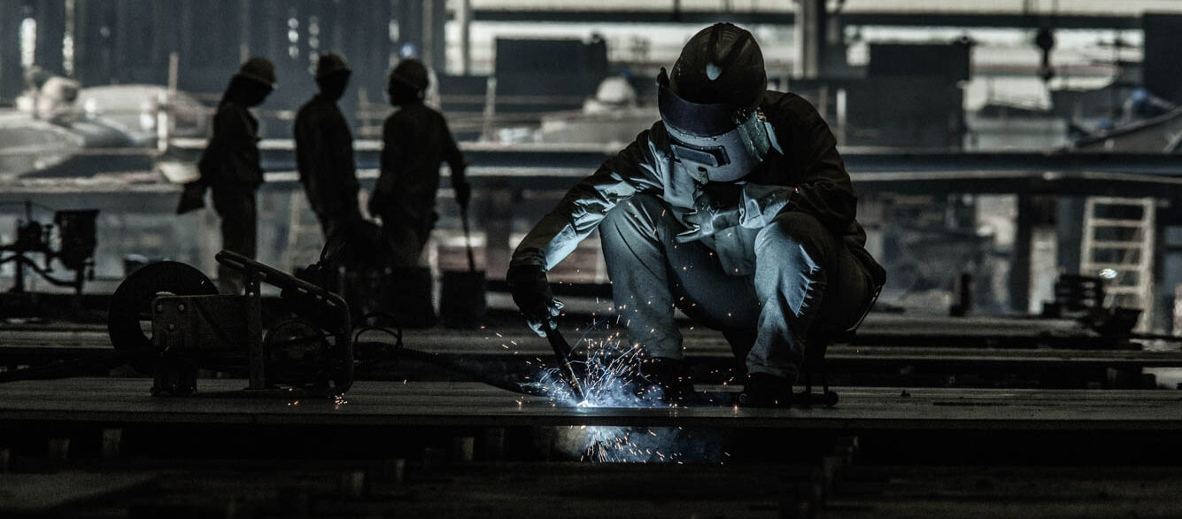 Welder working at a ship building yard in China.