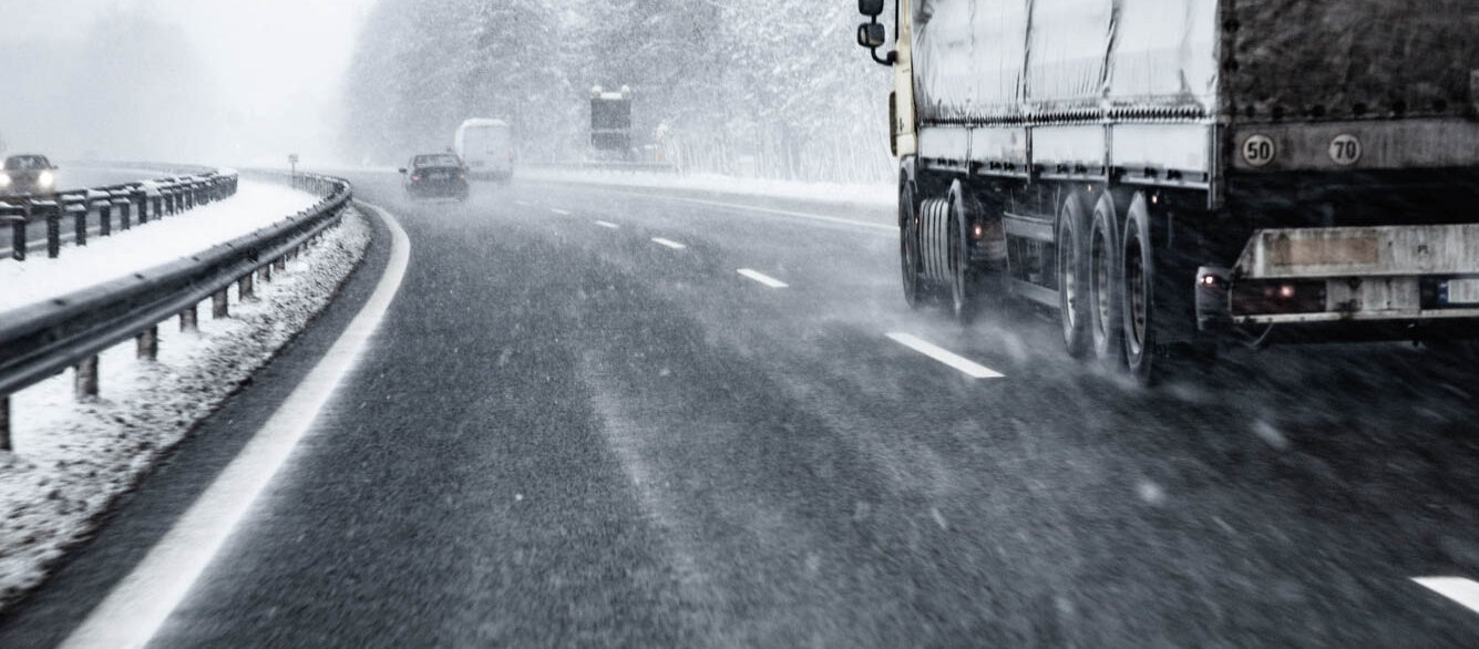 Truck Driving on Wet and Slippery Highway in Winter